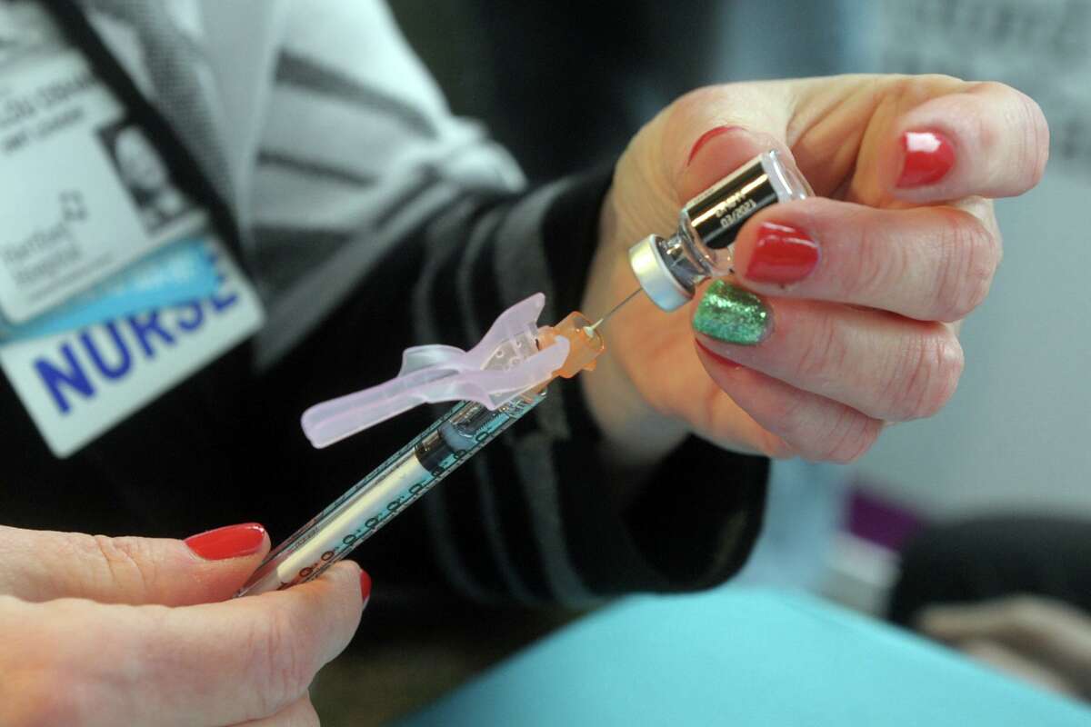 A nurse prepares a syringe with one of the first doses of the Pfizer COVID-19 vaccine during a news conference outside of Hartford Hospital, in Hartford, Conn. Dec. 14, 2020.