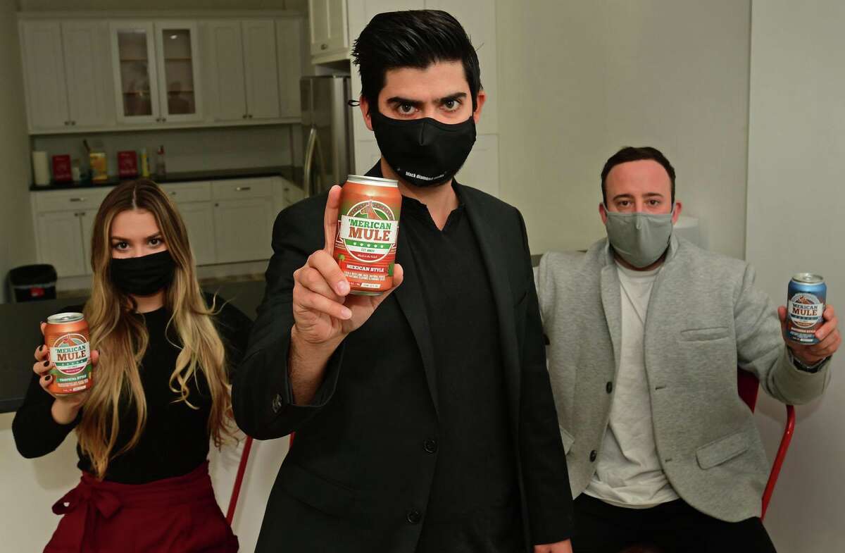 ' Merican Mule CEO Dean Mahoney with his employees Hailee Parenteau and Adam Scalfani at their new offices Tuesday, December 15, 2020, in Norwalk, Conn. With Reed's having launched this year a Moscow Mule canned cocktail, Norwalk's Merican Mule is a second vendor in the business with eyes on national distribution. The company is backed by Sobe/Blue Buffalo founder Bill Bishop and advised by Dave Holmes, one of the tandem who built SpikedSeltzer prior to its big sale to AB-InBev.