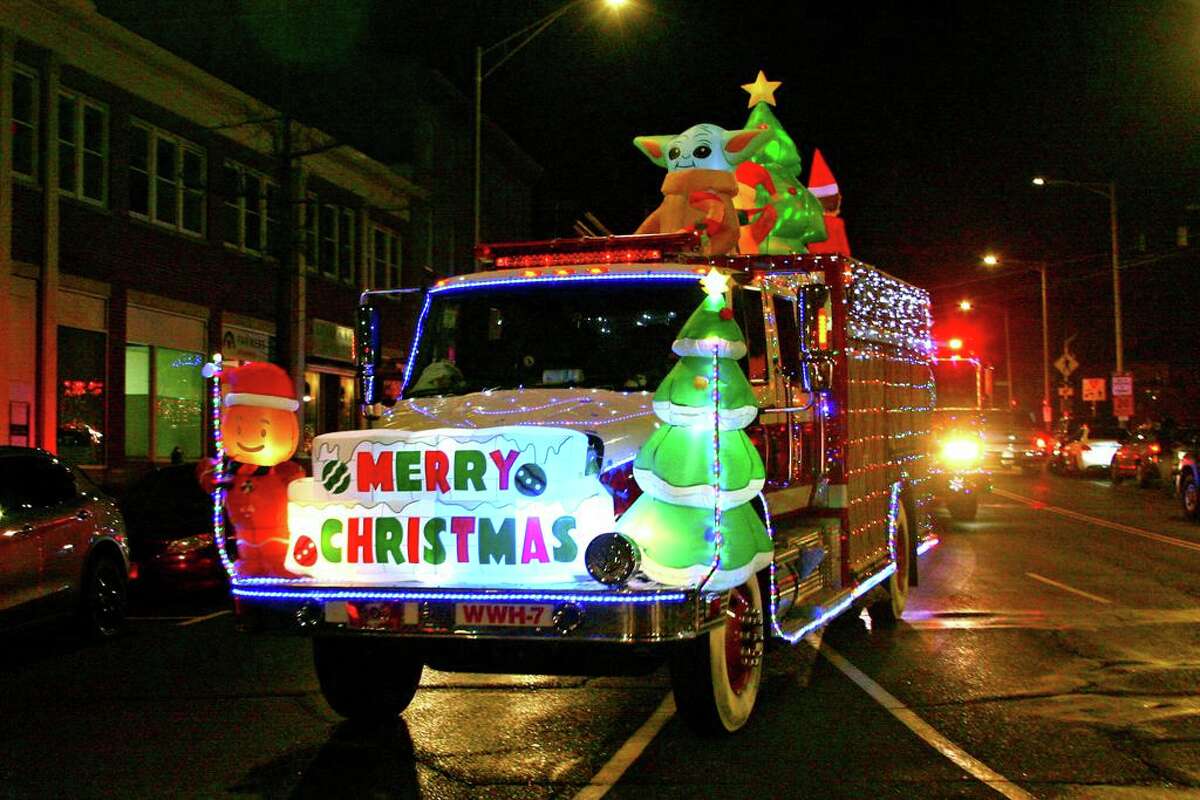 In this file photo, decorated Danbury Fire Department trucks make their way through downtown Danbury in a parade to celebrate the start of the Christmas holiday after a tree lighting at the Danbury Public Library in downtown Danbury, Conn., on Dec. 4, 2020. The coronavirus pandemic forced the event to be scaled down and shown virtually online.