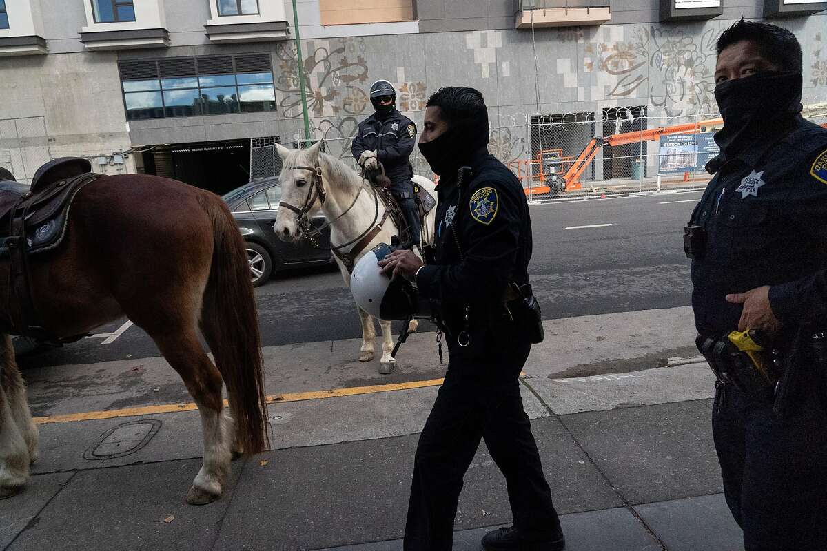 Oakland Officers Bryant Ocampo (right) and Daniel Cornejo-Valdivia visit with an officer on horseback patrolling downtown. The Police Department has eliminated details that put extra officers in areas with high rates of violent crime.