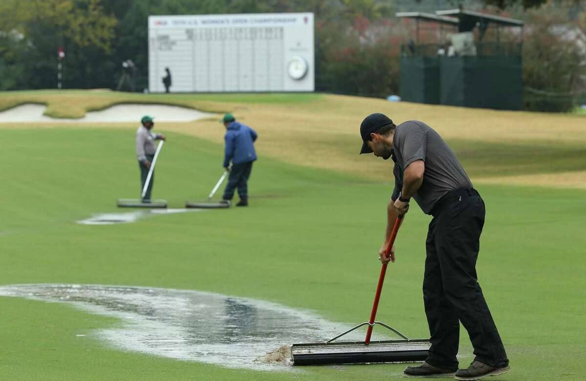 Grounds crew work on the 18th hole on Cypress Creek Course after a downpour during the final round of the 75th Annual U.S. Women's Open on the at Champions Golf Club in Houston on Sunday, Dec. 13, 2020. The tournament was suspended until Monday due to the weather.