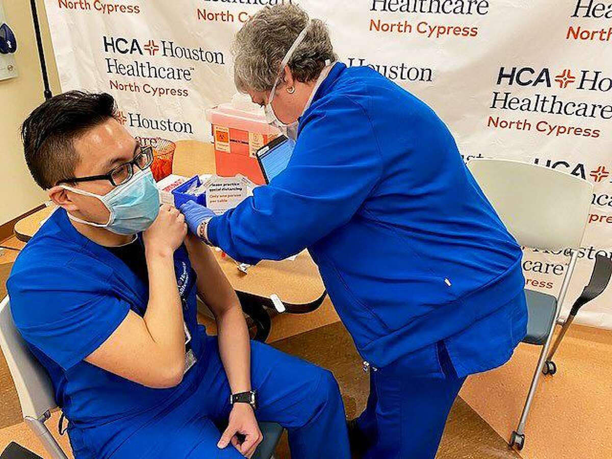 Kevin Han receives his first round dosage of the Pfizer vaccine from Nurse S Noble. Vaccinations across HCA Healthcare hospitals began early Friday morning and will continue round the clock until all 22,000 staff members are finished.