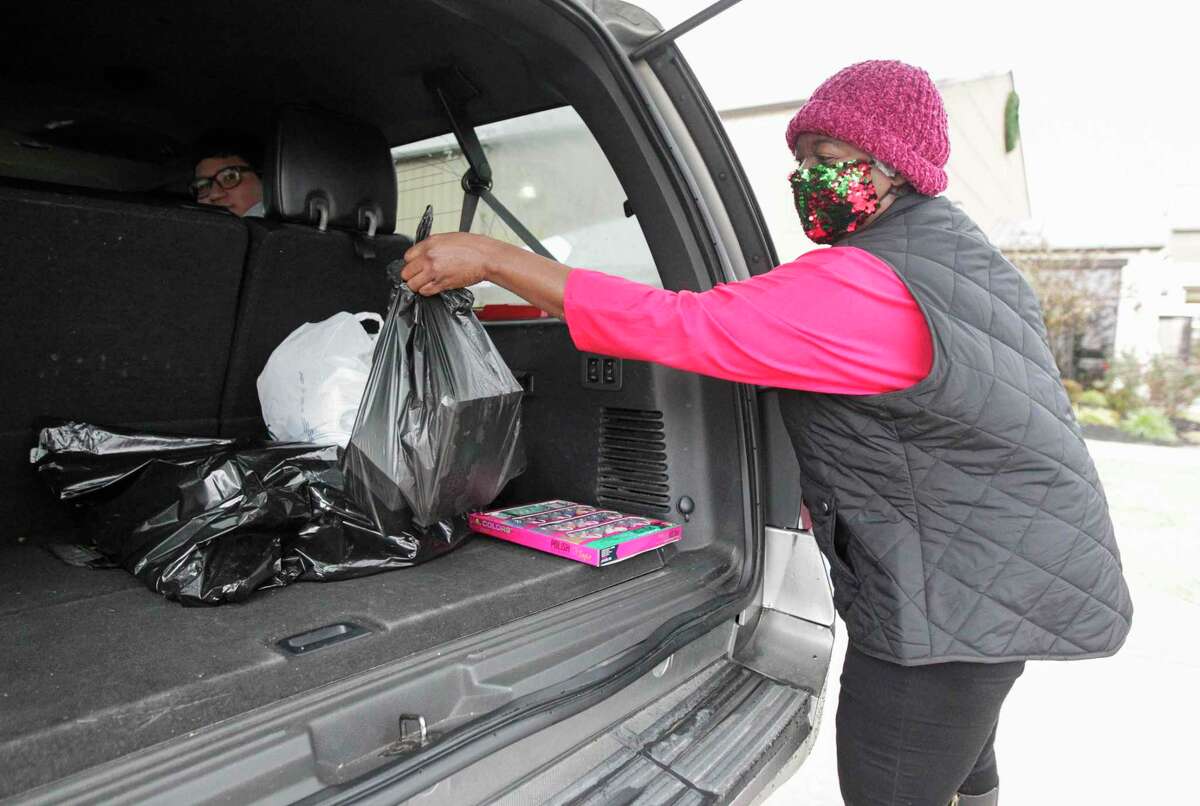 Annette Easley helps load food into vehicles as volunteers help distribute more than 500 meals at Fellowship of Montgomery, Saturday, Dec. 19, 2020, in Montgomery. Montgomery County United partnered with The Montgomery County Food Bank, Fellowship of Montgomery, Good Brothers and Sisters of Montgomery County and Easley Enterprises of TX Inc. to provide meals for families and individuals before the Christmas holiday.