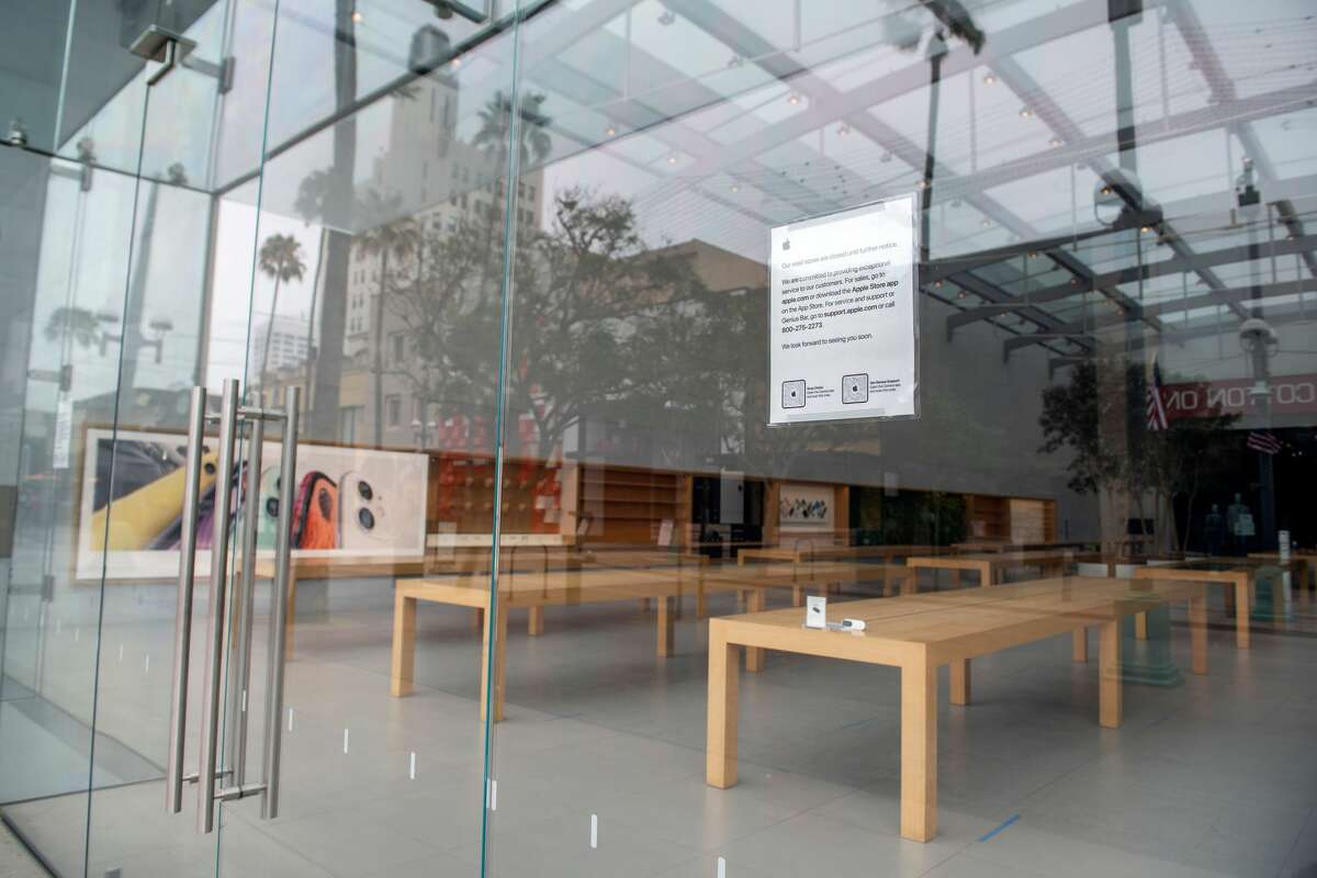 Des panneaux sont visibles sur une fenêtre pour avertir les consommateurs que l'Apple Store de Santa Monica, en Californie, est fermé le 28 juillet 2020, au milieu de la pandémie de coronavirus.