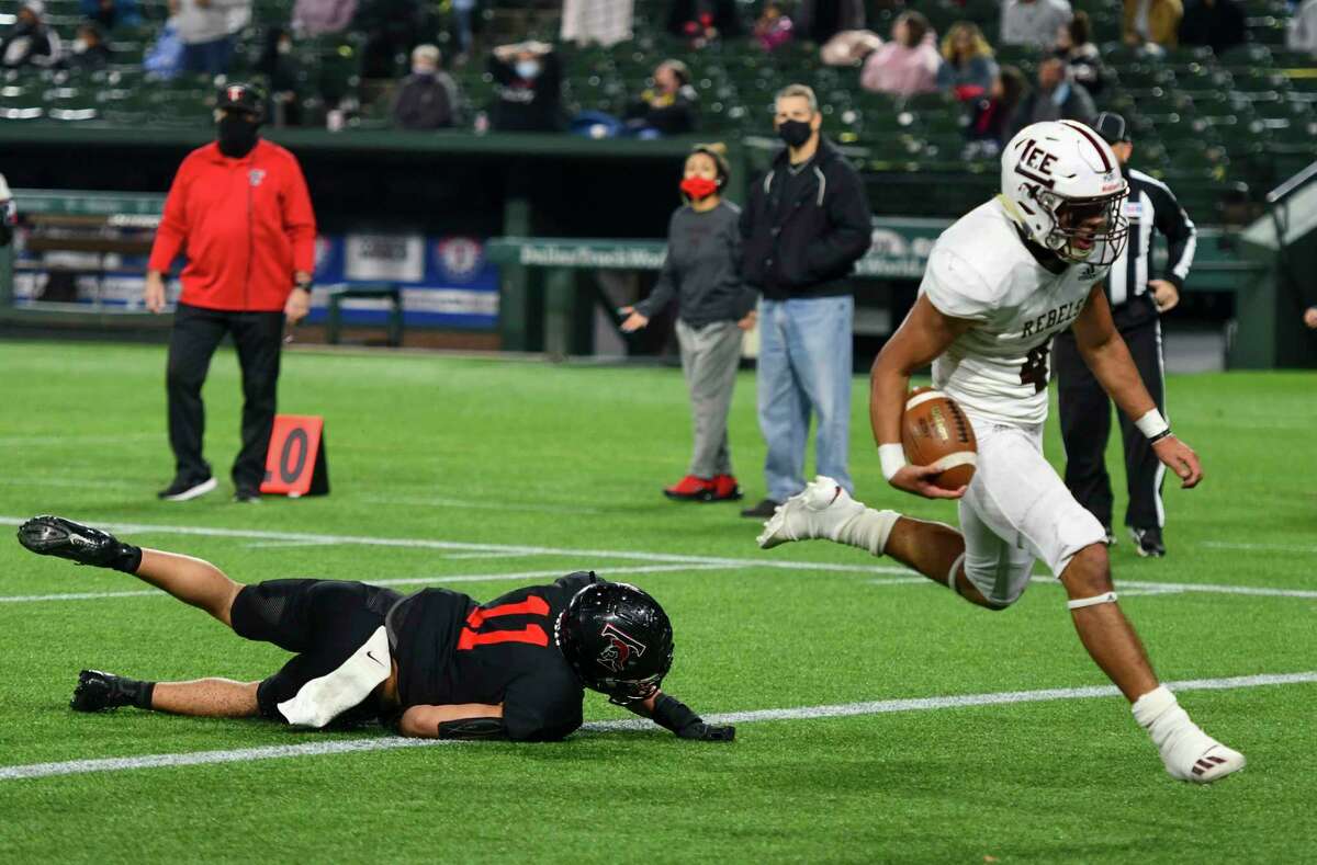Lee’s Mikey Serrano (4) runs in for a touchdown as Trinity’s Sateki Wolfgramm (11) trips behind him Saturday, Dec. 19, 2020 at Globe Life Park in Arlington. Jacy Lewis/Reporter-Telegram