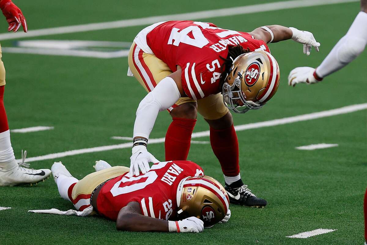 \Middle linebacker Fred Warner #54 calls out medical staff for free safety Jimmie Ward #20 of the San Francisco 49ers after Ward after collided with wide receiver CeeDee Lamb #88 of the Dallas Cowboys during the second quarter at AT&T Stadium on December 20, 2020 in Arlington, Texas.