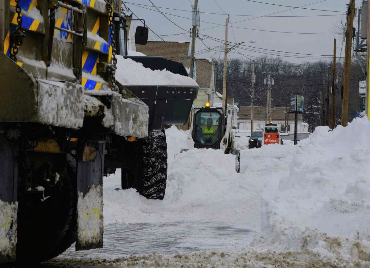 Crews work to remove snow from Edward St. on Sunday, Dec. 20, 2020, in Schenectady, N.Y. New York State Department of Transportation dump trucks were used to haul the snow away. (Paul Buckowski/Times Union)