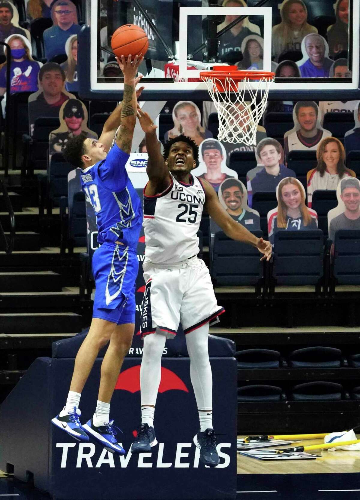 Creighton’s Christian Bishop (13) shoots as UConn’s Josh Carlton defends in overtime on Sunday.