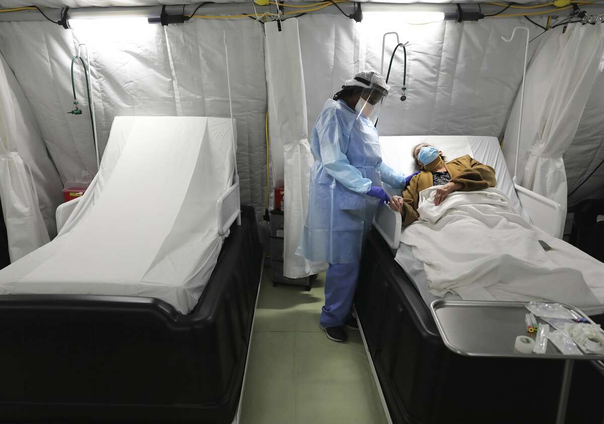 Nurse Jave Blackburn comforts COVID-19 patient Alma Stokes in the Infusion tent unit at Covenant Hospital in Lubbock, Texas.