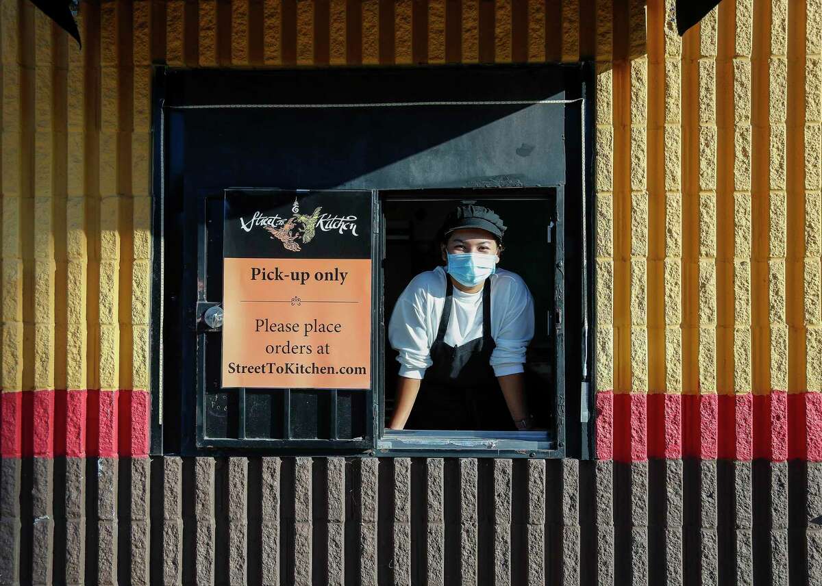 Chef Benchawan Painter in the drive-thru window of his East End Thai restaurant, Street to Kitchen, which opened during the COVID-19 pandemic.