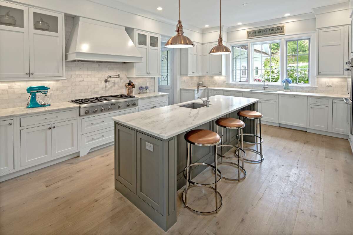 Gourmet kitchen at 2 Hidden Hill Road, Westport. Inside, there are four fireplaces - in the family room and library on the first floor, and one the second floor in the master bedroom suite and a sitting room on the same level. Off the dining room there is a butler's pantry that doubles as a wet bar when entertaining. It has a patterned marble backsplash. In the gourmet kitchen there is a center island/breakfast bar, marble counters and backsplash, high-end appliances and a pot-filler above the range top. French doors in the family room open to the yard, pool and patios.