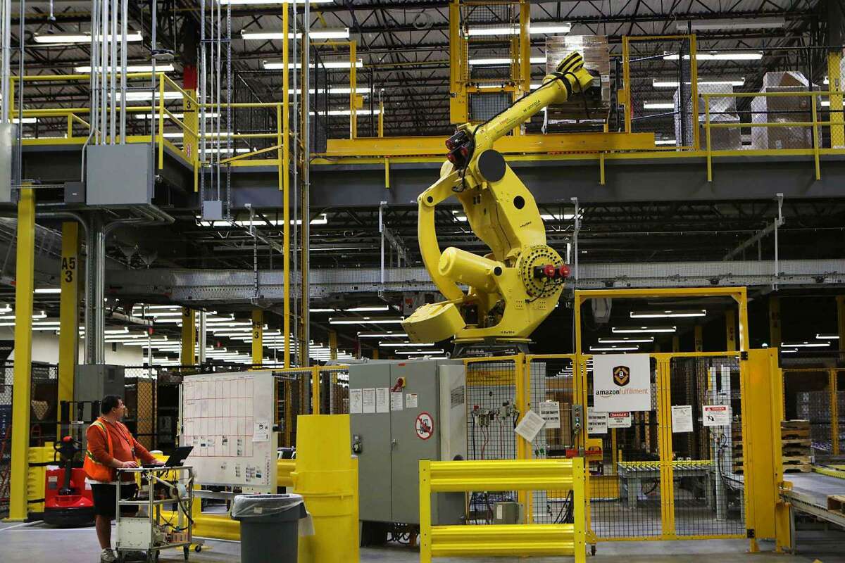 A mechanical arm called Robo-Stow lifts a pallet of goods to an upper shelf at Amazon’s fulfillment center in Schertz. The company is opening two fulfillment centers in San Antonio, as well as a delivery station.