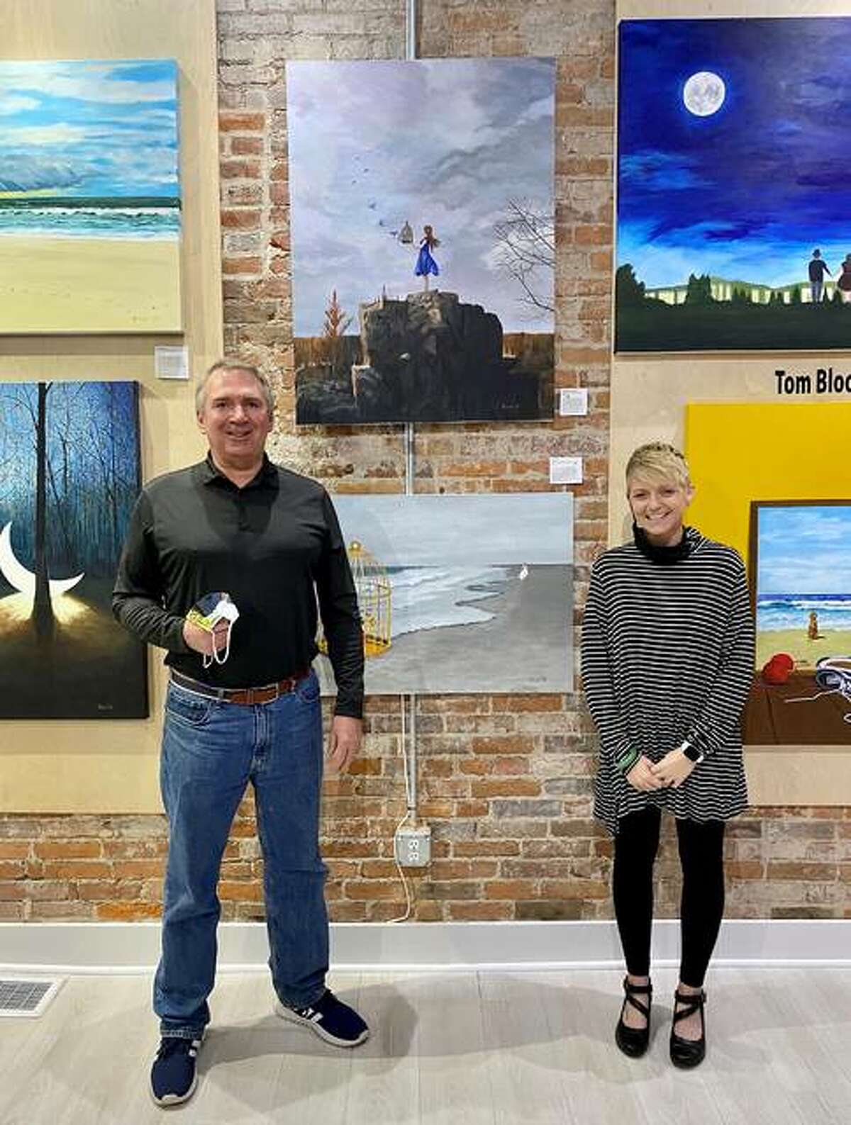 Artist Tom Blood and gallery owner/curator Brooke Piepert stand in front of the painting, “Happiness Released,” at Good Weather Gallery in Edwardsville.