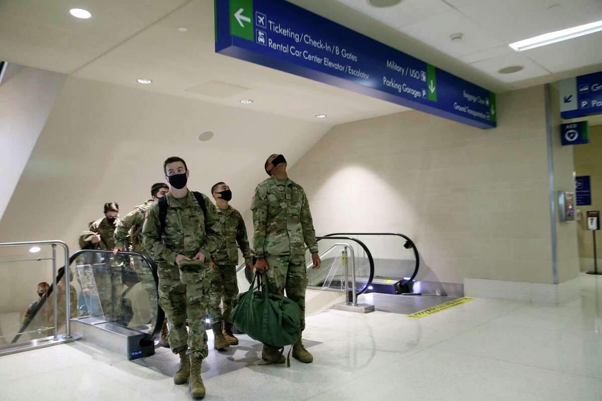 U.S. Army Pvt. Kevin Rinke, 18, left, of Spanaway, Washington, and Pfc. Marlon Brownfield, 19, of Hampton, Georgia, arrive with other soldiers at the San Antonio International Airport on their way for the holiday break, Tuesday, Dec. 22, 2020. Troops from Joint Base San Antonio started the annual exodus on Saturday and will continue through part of this week.