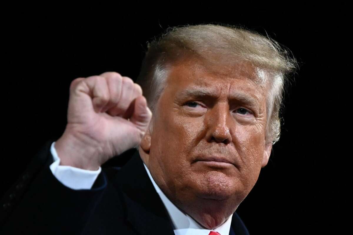 President Donald Trump raises his fist at the end of a rally to support Republican Senate candidates at Valdosta Regional Airport in Valdosta, Georgia on December 5, 2020. -  (Photo by Andrew CABALLERO-REYNOLDS / AFP)