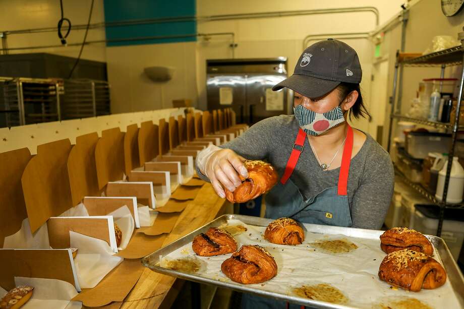 Bake Sum糕点的面包师和创始人乔伊斯·唐(Joyce Tang)将糕点放入将于2020年12月11日星期五在加利福尼亚州伯克利出售给客户的盒子中。图片来源:Yalonda M. James / The Chronicle