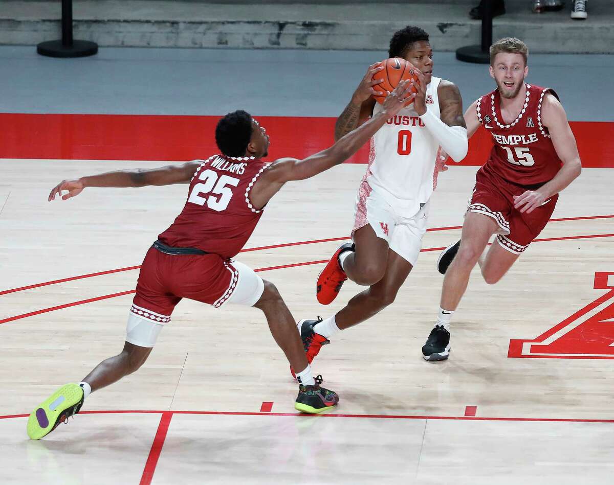 Houston Cougars guard Marcus Sasser (0) works against Temple Owls guard Jeremiah Williams (25) and Brendan Barry (15) during the first half of an NCAA men's basketball game at Fertitta Center, Tuesday, December 22, 2020, in Houston.