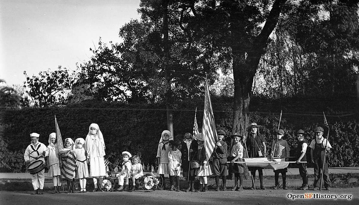 Children line up for a parade in San Francisco in 1918, wearing masks and carrying a stretcher. The influenza of 1918-1919 killed more than 3,500 San Franciscans.