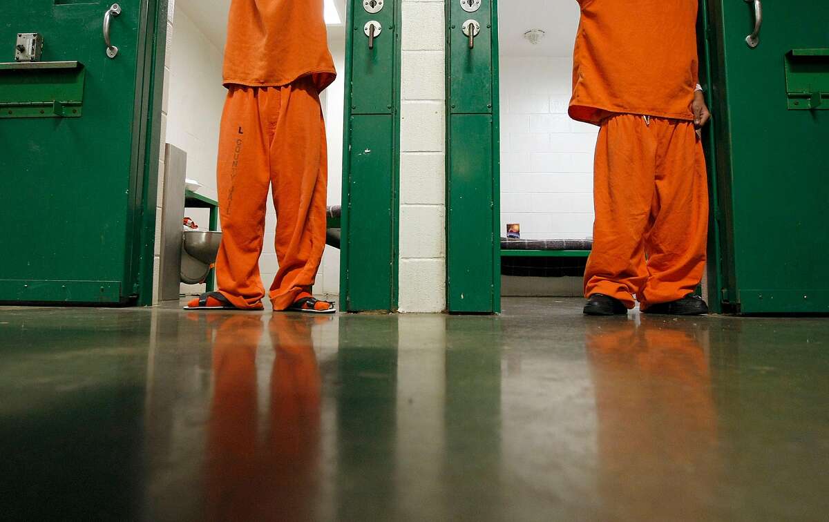 Two 16 and under juveniles who have been charged as adults stand in their cells at the Harris County Jail in Houston.