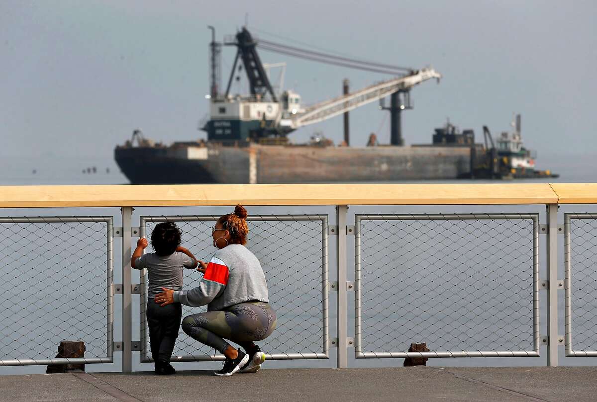 Laura Santiago and her son Anthony Gutierrez admire the view of boats and barges on the bay at the new Crane Cove Park near Pier 70 in San Francisco.