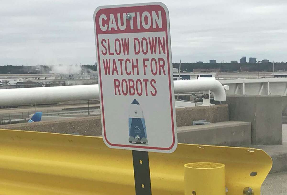 A sign in the parking lot at Terminal C at Bush Intercontinental Airport warns drivers to look out for robots as they enter and exit the garage. Two Knightscope K5 robots are patrolling the garage as part of a one-year pilot program.