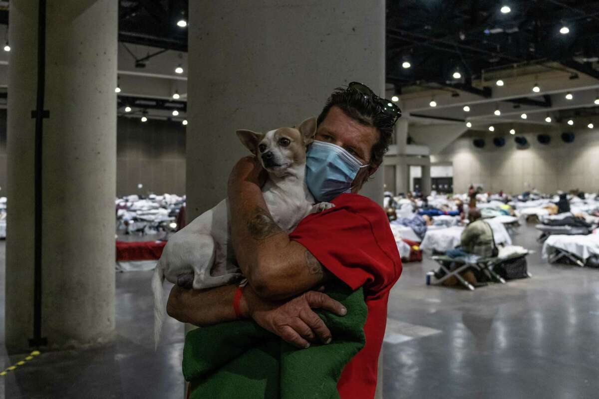 Justice Everett holds his dog Rocky inside the San Diego Convention Center on Oct. 28, 2020. He said he became homeless after losing his job around the time the pandemic began.