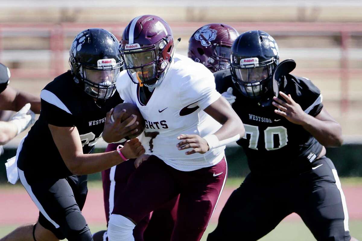 Heights quarterback Jalen Morrison (7) pushes past Westside defenders Kevin Soto, left, and Jared Gay (70) during their game at Butler Stadium Saturday, Oct. 31, 2020 in Houston, TX.