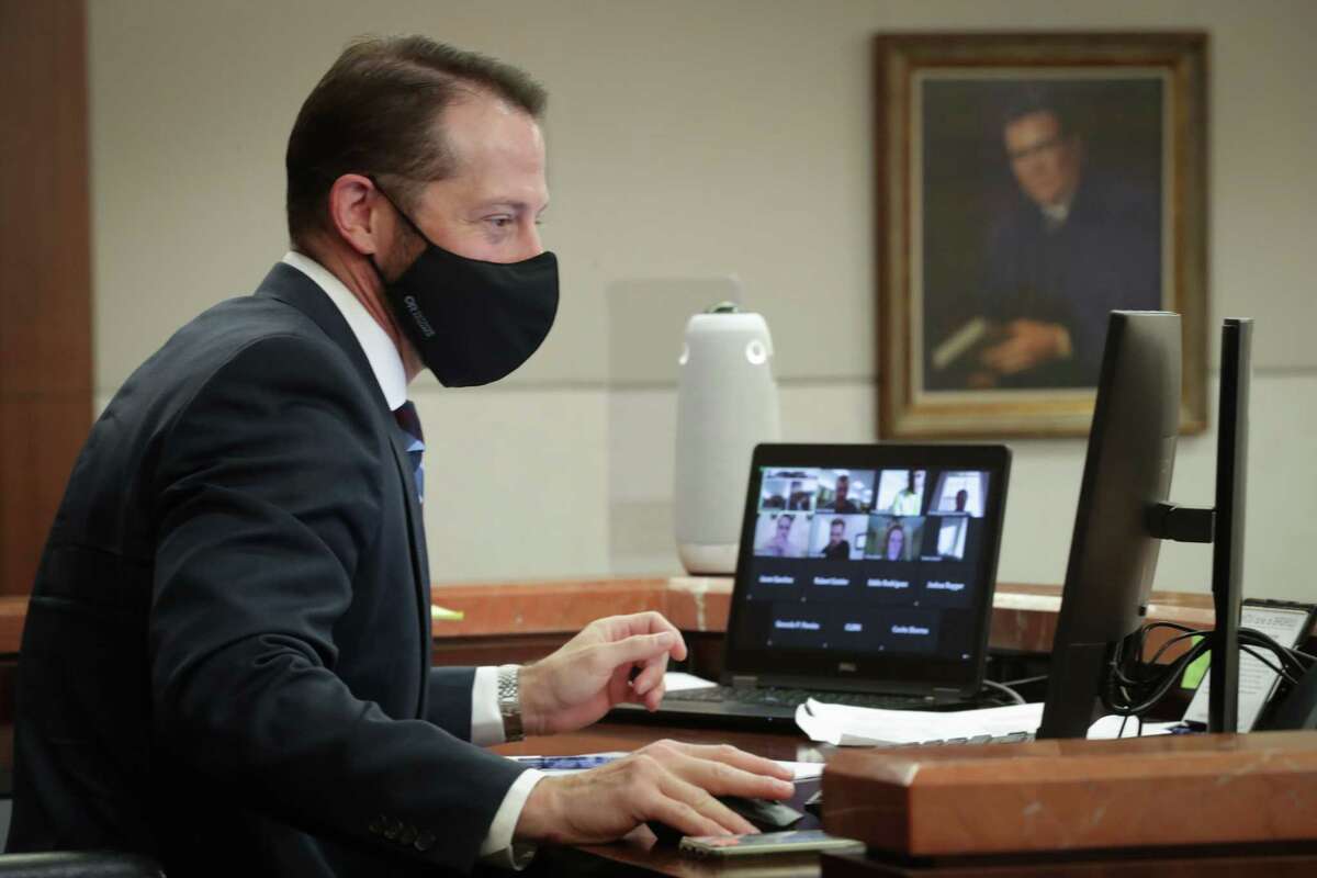 Judge Josh Hill uses Zoom conferencing to conduct courtroom hearings in the Harris County Criminal Justice Center 232nd Criminal Court Wednesday, Dec. 16, 2020, in Houston.