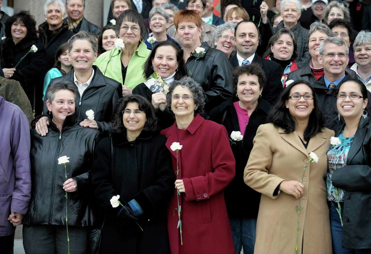 Couples pose for a photograph marking the one-year anniversary of the day Connecticut began allowing same-sex marriage in Hartford in 2009.