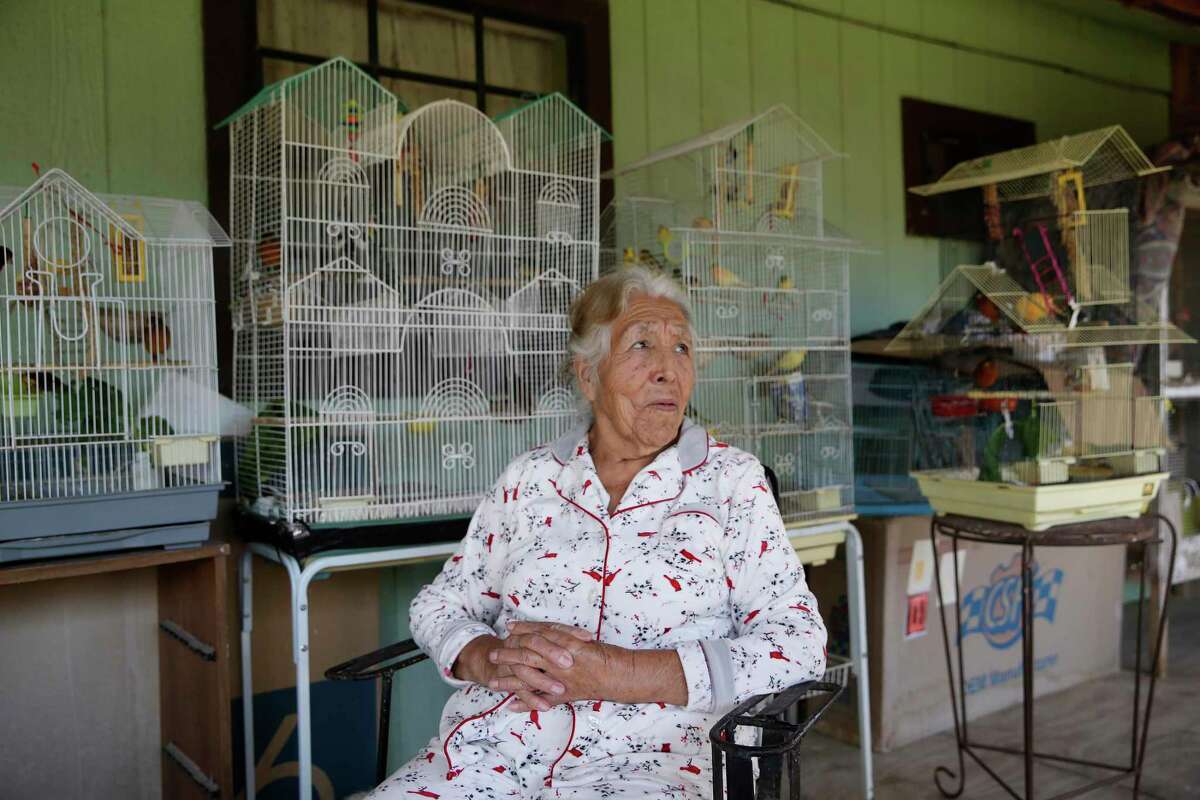 Eighty-four-year-old Juana Herrera sits with her canaries at her home in the Hoehn Drive colonia outside Edinburg, Texas, Monday, Dec. 21, 2020. Residents of the colonia and others in the area were surprised by an overdue $1,400 tax bill from the Hidalgo County Irrigation District 1, dating back to the mid-1980?•s. Herrera bought her property in the 1990?•s and was not aware of such tax that is for irrigation of farmland.