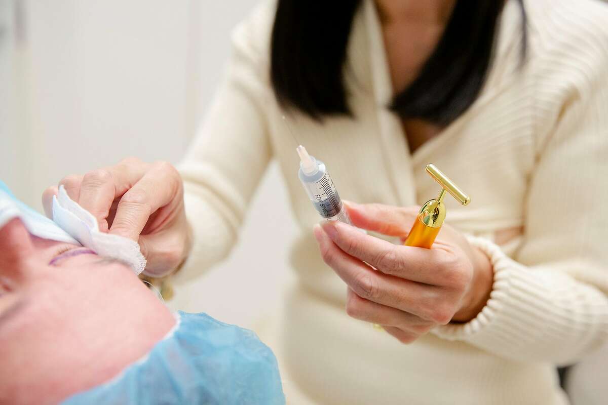 Dr. Carolyn Chang prepares to give a patient anesthetic shots prior to starting a blepharoplasty, or eyelid surgery, at her office in San Francisco, Calif.
