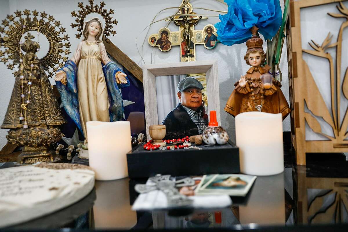 An altar for Jesus Baluyot, the husband of Mariquita Baluyot and father of Jenilee Silva and Jasmine Igtanloc, sits on a dresser at Jasmine’s home in Redwood City.