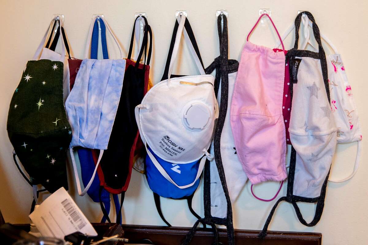 Masks hang in the foyer of UCSF physician Dr. Madhavi Dandu's home in San Francisco, Calif. Tuesday, December 22, 2020. Dandu was one of the first to receive the Pfizer COVID-19 vaccine at UCSF, where she works as a physician. Her husband Nima Afshar, an ER doctor at the San Francisco VA Medical Center, will be getting the Moderna vaccine this week.