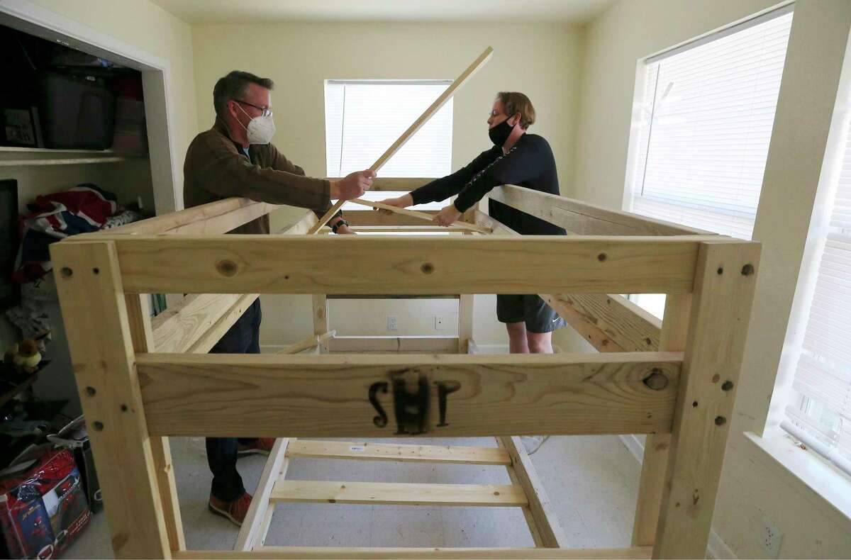 Shane Arnold (left) and his son Gavin, 15, install a bunk bed from Sleep in Heavenly Peace at Jessica Cabot’s home on Christmas Eve. Since 2018, the nonprofit Sleep in Heavenly Peace has built and delivered beds to families who were in need of beds for children who mostly slept on air mattresses, couches or even on floors.