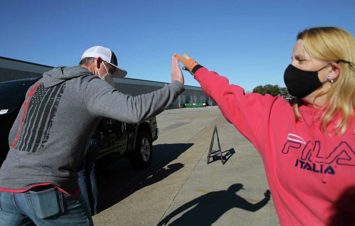 Sleep in Heavenly Peace Chapter President Eddie Arnold and a volunteer give each other a high-five as they help load beds to be delivered and installed at homes of families in need on Thursday, Dec. 24, 2020. Since 2018, the nonprofit Sleep in Heavenly Peace has built and delivered beds for kids who were sleeping on air mattresses, couches or even on floors. On Christmas Eve, the group, led by Arnold, delivered and installed 160 beds.