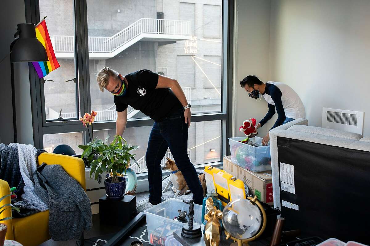 Christopher Beale (left) and Reagan Rockzsfforde unpack in their new S.F. apartment after moving from Oakland last month.