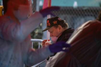 Richard Elizares self-swab a Covid-19 test in the Latino Cultural District on Thursday, Dec. 24, 2020 in San Francisco, Calif. State health data shows test positivity rate in disadvantaged areas is roughly double the county’s overall positivity rate. The vendor Virus Geeks is using the self-swabbing method that is twice a fast then before to administer.