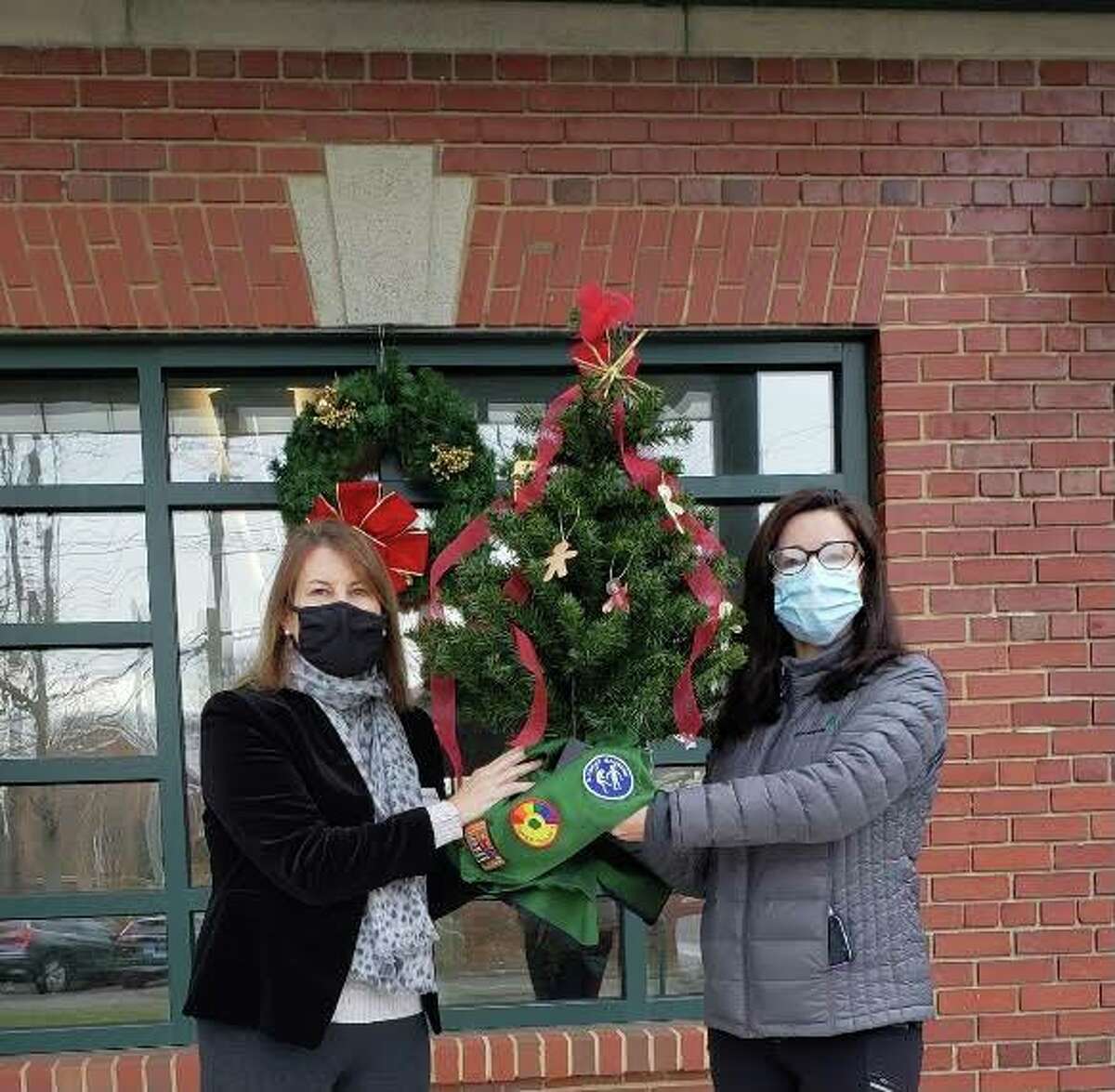 Anne Murdock, River House’s development director, left, accepts a tree decorated by Greenwich Girl Scouts from Greenwich Girl Scouts co-Service Unit Manager Kim Sushon, right.