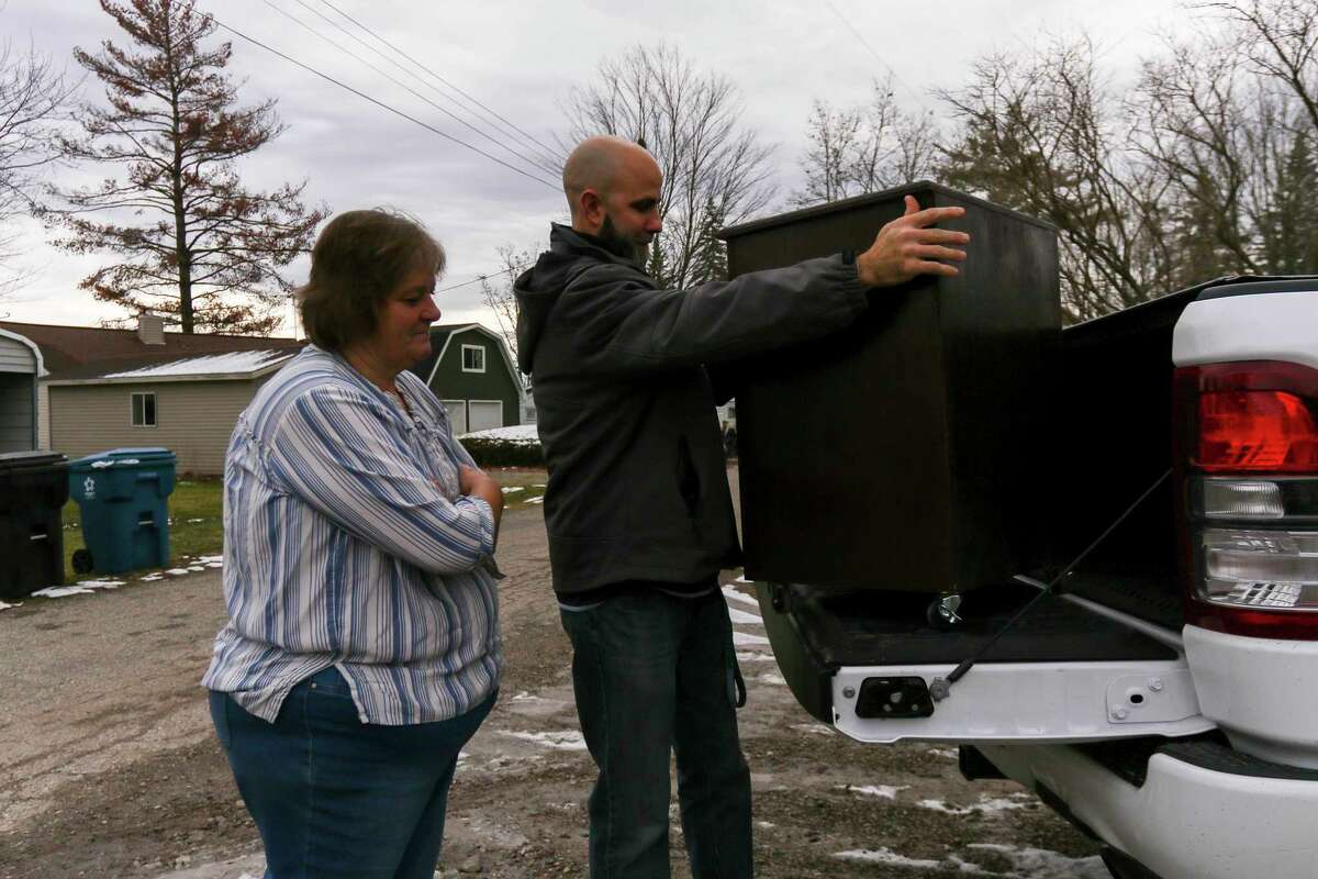 Meridian Junior High industrial education teacher Andy LaFave delivers nightstands to Carleen Campbell Wednesday, Dec. 23 in Sanford. Nightstands were made by LaFave's class of seventh- and eighth-graders to give to residents whose homes were flooded last May. (Cody Scanlan/for the Daily News)