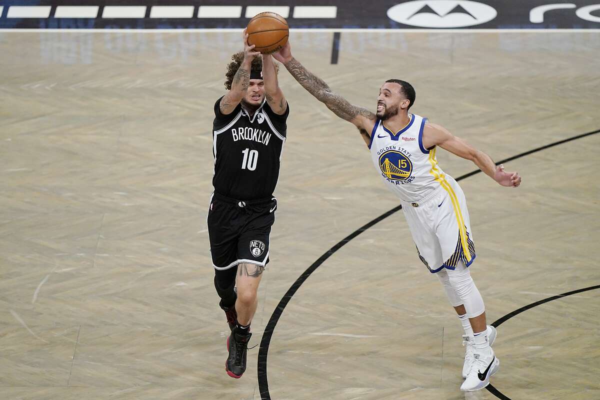 Golden State Warriors guard Mychal Mulder (15) defends against a pass by Brooklyn Nets guard Tyler Johnson (10) during the second half of an opening night NBA basketball game, Tuesday, Dec. 22, 2020, in New York. (AP Photo/Kathy Willens)