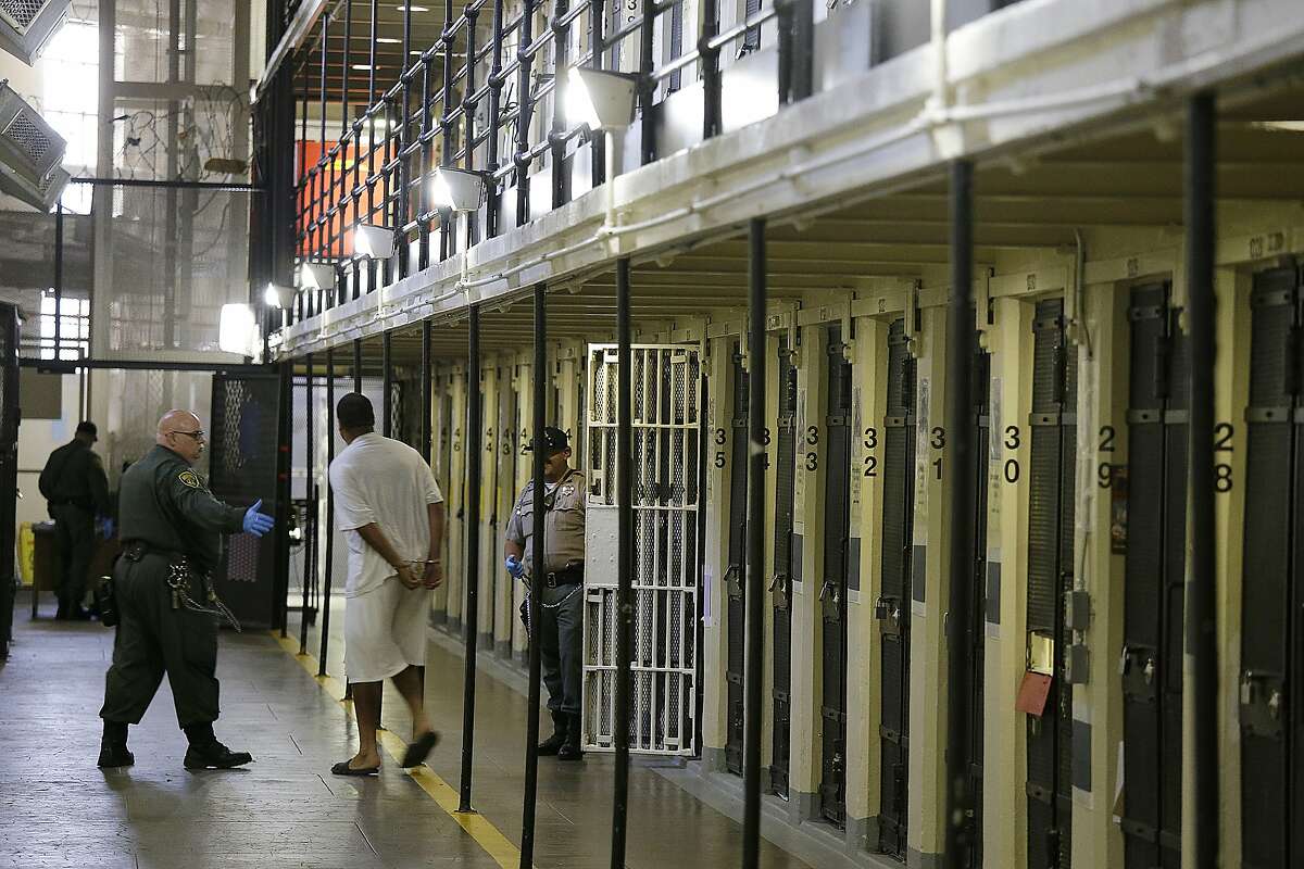 An inmate is led out of his cell at San Quentin State Prison on Aug. 16, 2016. The state Supreme Court ruled Monday that a voter-approved initiative that allowed early parole consideration for prisoners convicted of nonviolent felonies applies to thousands of inmates serving time for nonforcible sex crimes such as pimping and possessing child pornography.