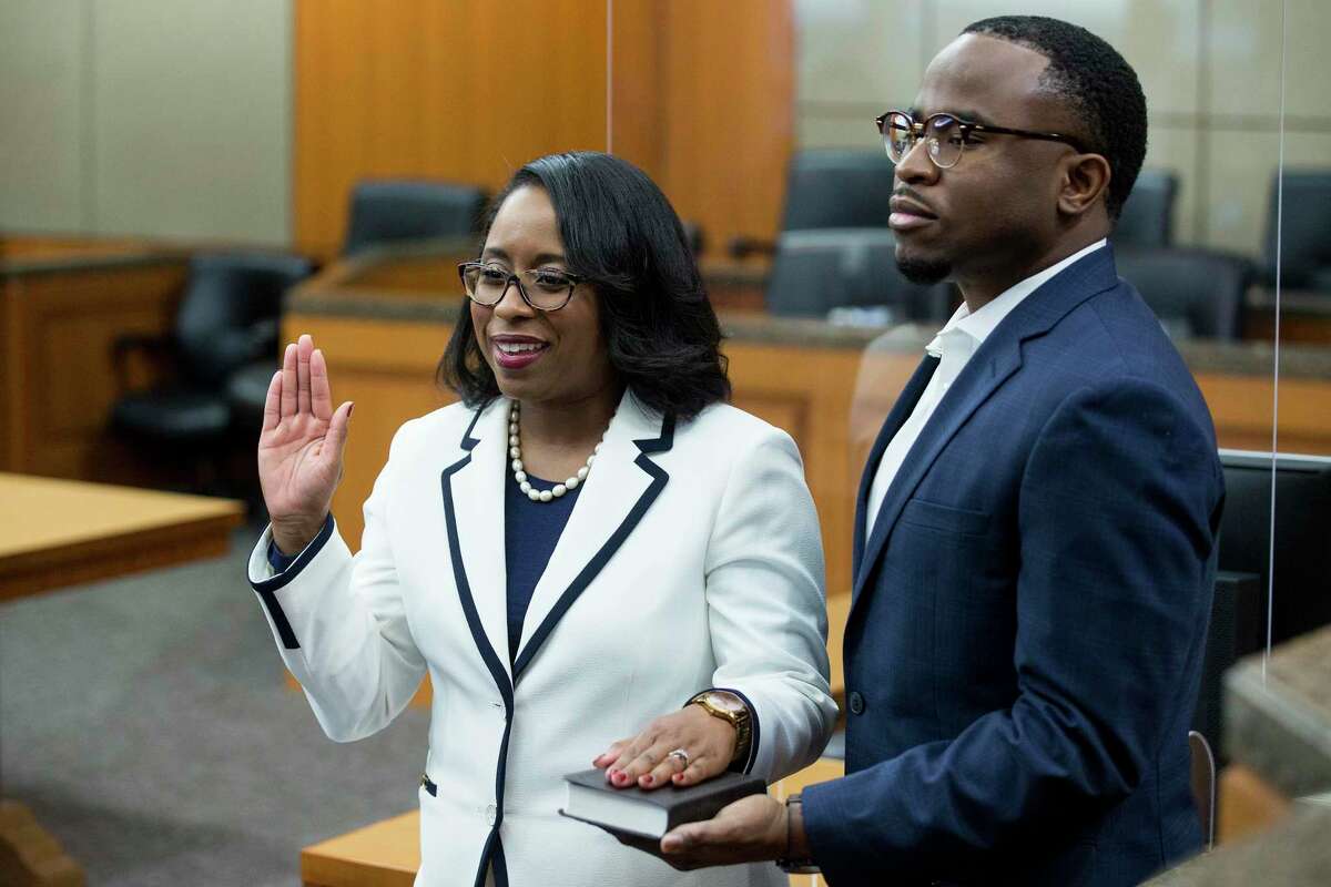 Texas Southern University alumna Teneshia Hudspeth stands with her husband, Samson Babalola, as she is sworn in as the new Harris County Clerk, by Judge Lesley Briones Tuesday, Nov. 17, 2020 in Houston.