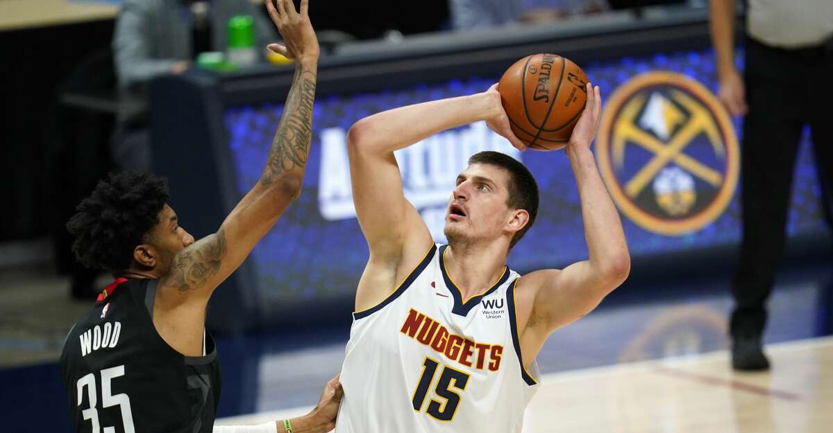 Denver Nuggets center Nikola Jokic, right, shoots over Houston Rockets forward Christian Wood in the first half of an NBA basketball game Monday, Dec. 28, 2020, in Denver. (AP Photo/David Zalubowski)
