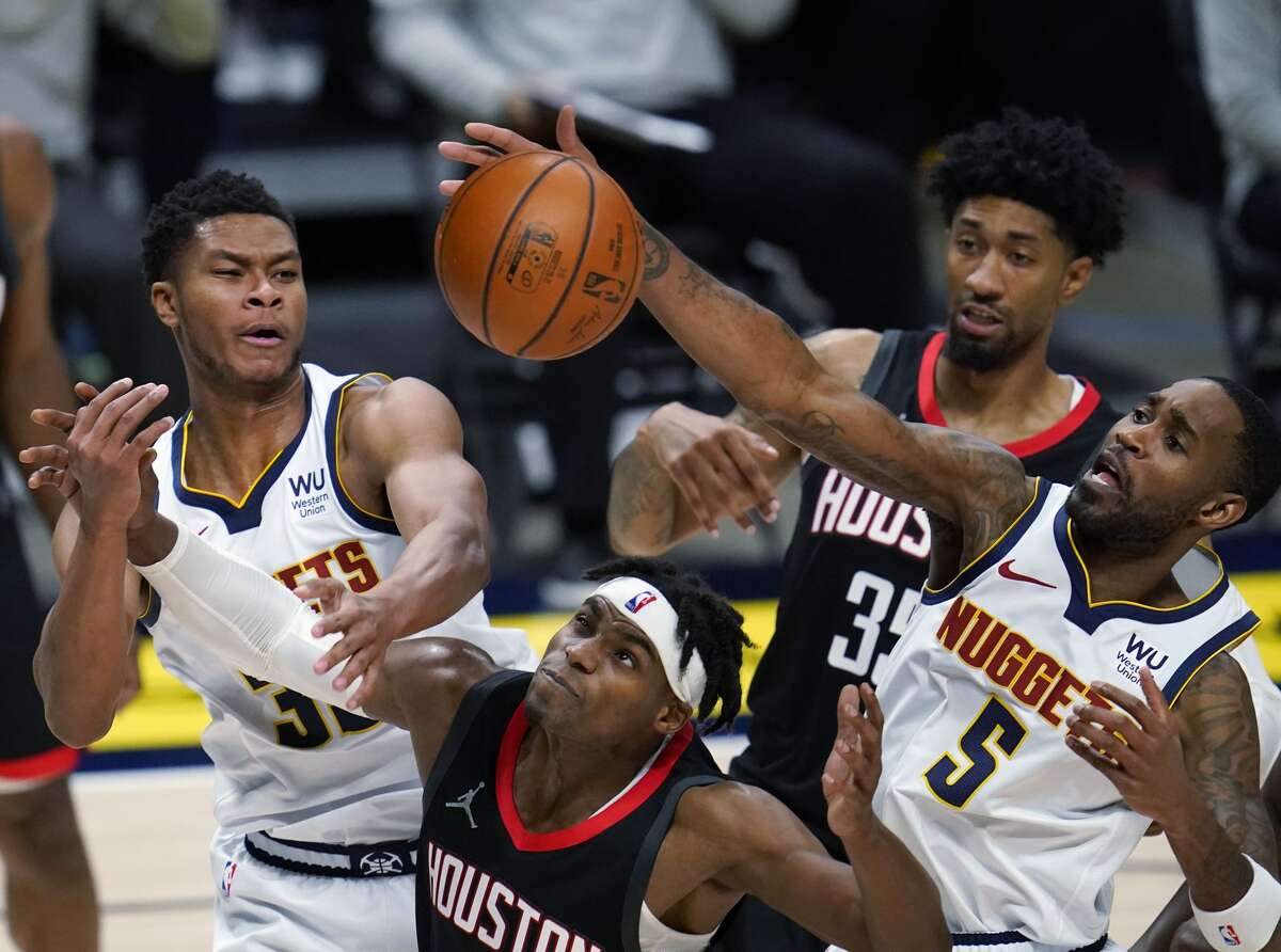 Denver Nuggets guard Will Barton, front right, swats away the ball next to Houston Rockets forwards Christian Wood, back right, and Danuel House Jr., as Denver guard PJ Dozier watches during the first half of an NBA basketball game Monday, Dec. 28, 2020, in Denver. (AP Photo/David Zalubowski)