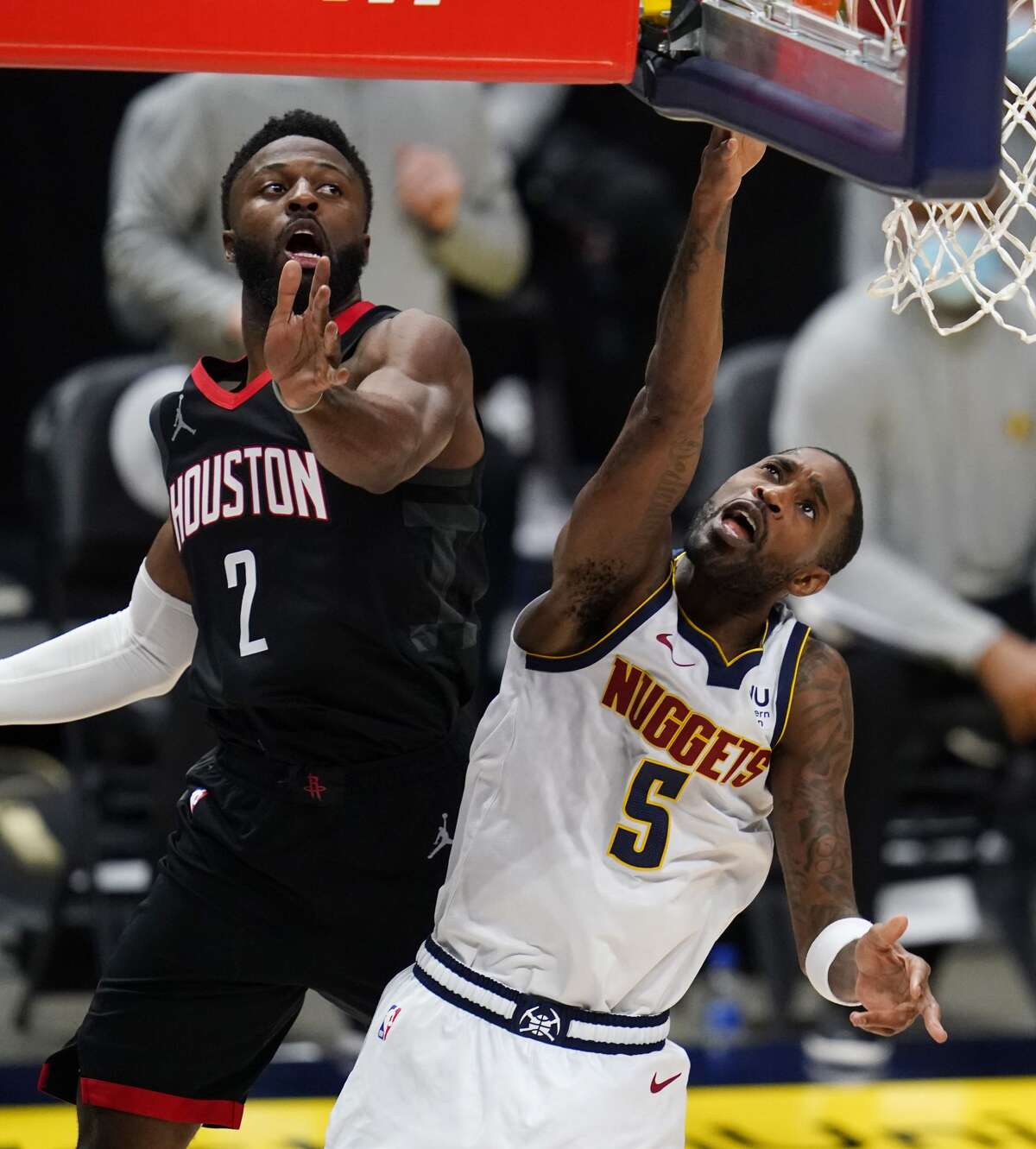 Denver Nuggets guard Will Barton shoots next to Houston Rockets guard David Nwaba during the first half of an NBA basketball game Monday, Dec. 28, 2020, in Denver. (AP Photo/David Zalubowski)