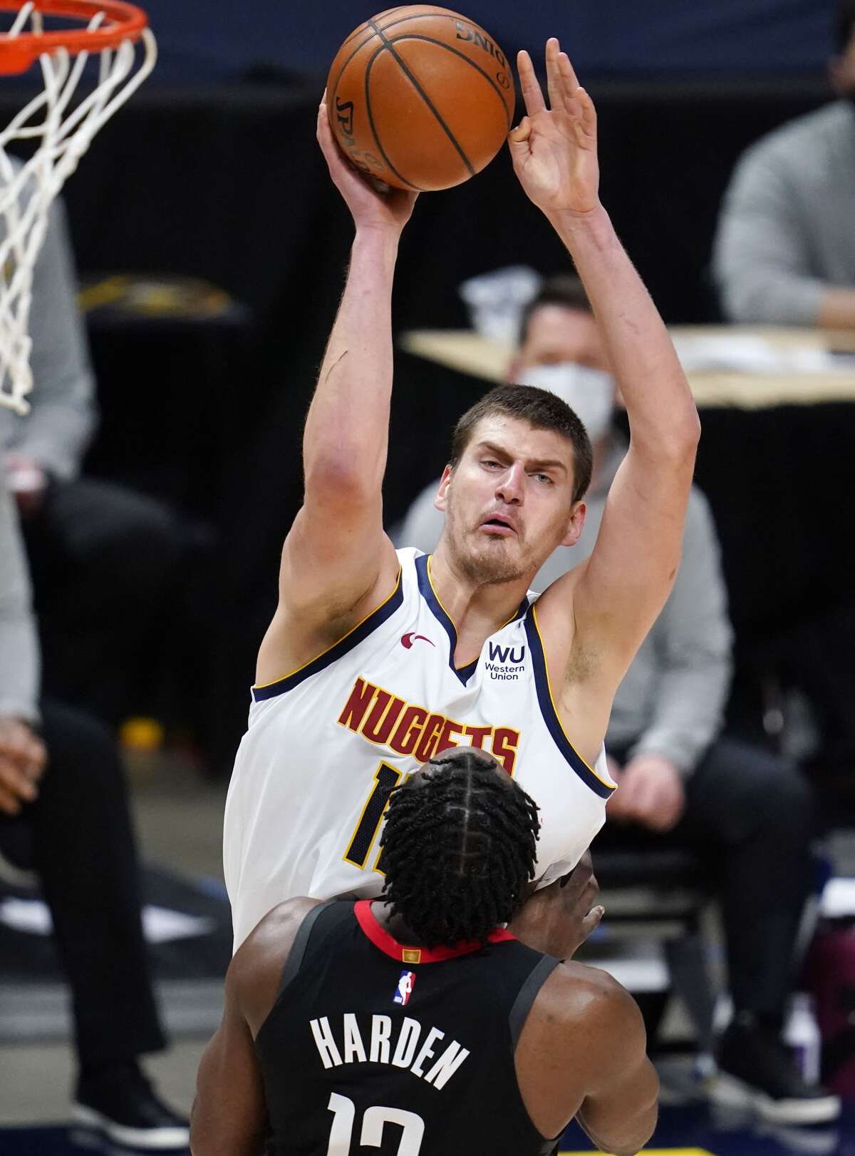 Denver Nuggets center Nikola Jokic, back, shoots for a basket over Houston Rockets guard James Harden in the first half of an NBA basketball game, Monday, Dec. 28, 2020, in Denver. (AP Photo/David Zalubowski)