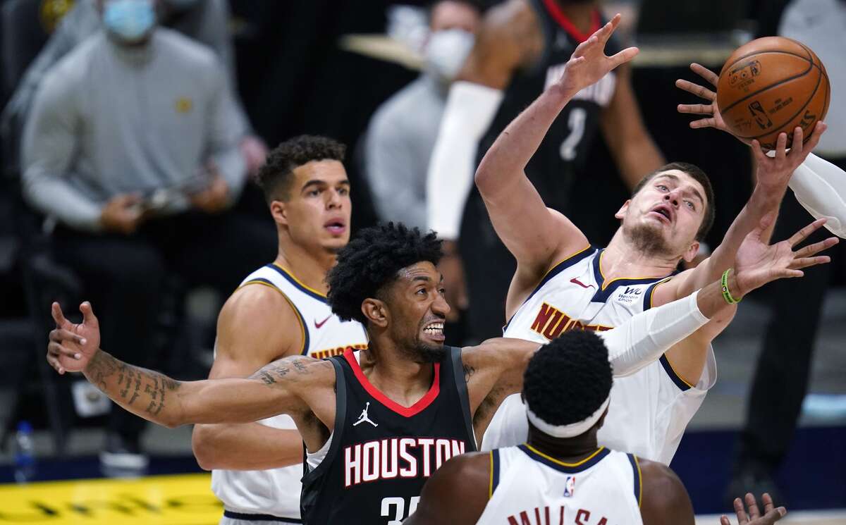 Denver Nuggets center Nikola Jokic, top right, pulls in a rebound as Houston Rockets forward Christian Wood defends, while Denver forwards Paul Millsap, front, and Michael Porter Jr. follow the play during the second half of an NBA basketball game Monday, Dec. 28, 2020, in Denver. (AP Photo/David Zalubowski)