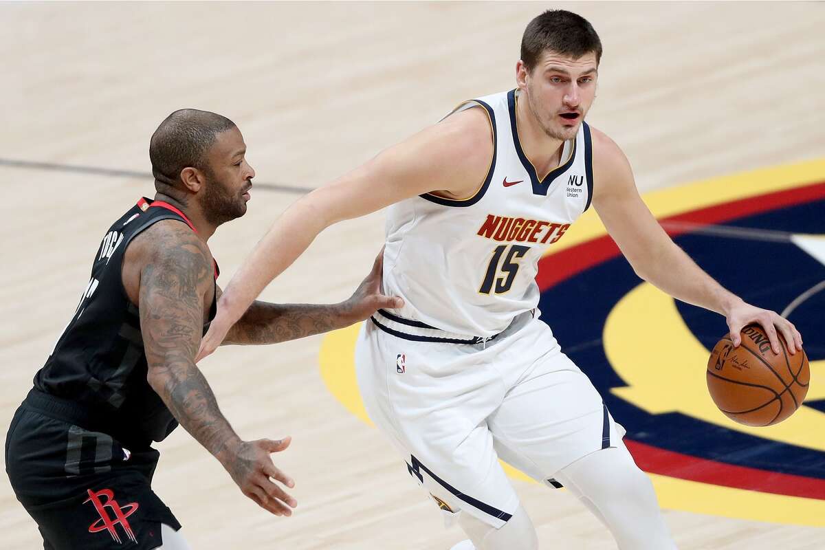 DENVER, COLORADO - DECEMBER 28: Nikola Jokic #15 of the Denver Nuggets drives against P.J. Tucker #17 of the Houston Rockets in the first quarter at Ball Arena on December 28, 2020 in Denver, Colorado. NOTE TO USER: User expressly acknowledges and agrees that, by downloading and or using this photograph, User is consenting to the terms and conditions of the Getty Images License Agreement. (Photo by Matthew Stockman/Getty Images)