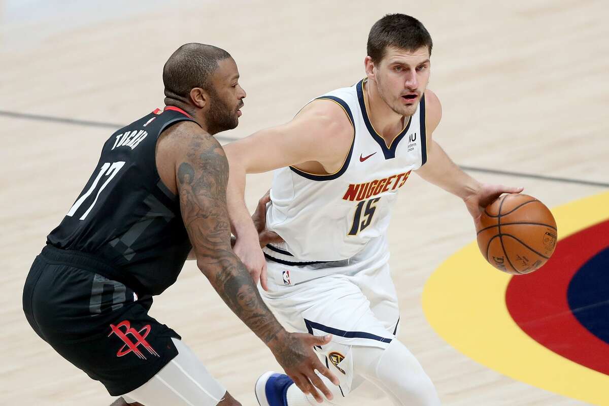DENVER, COLORADO - DECEMBER 28: Nikola Jokic #15 of the Denver Nuggets drives against P.J. Tucker #17 of the Houston Rockets in the first quarter at Ball Arena on December 28, 2020 in Denver, Colorado. NOTE TO USER: User expressly acknowledges and agrees that, by downloading and or using this photograph, User is consenting to the terms and conditions of the Getty Images License Agreement. (Photo by Matthew Stockman/Getty Images)