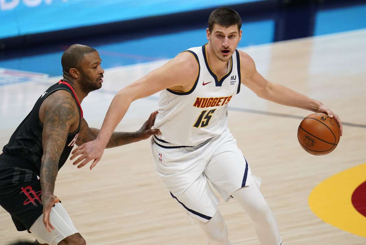 Denver Nuggets center Nikola Jokic drives against Houston Rockets forward P.J. Tucker during the first half of an NBA basketball game Monday, Dec. 28, 2020, in Denver. (AP Photo/David Zalubowski)